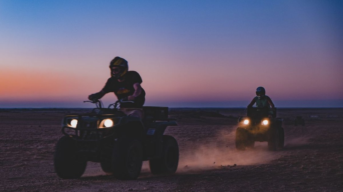 Quad bike riders at sunset in the desert near Agadir